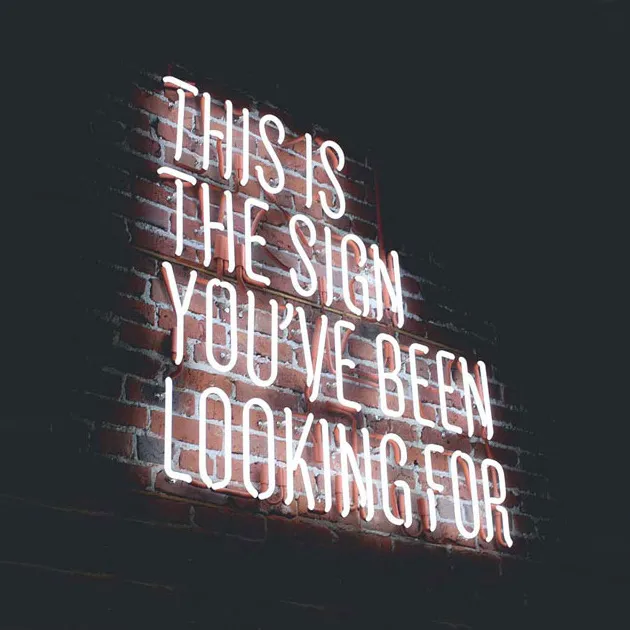 A neon sign reading "This is the sign you've been looking for".